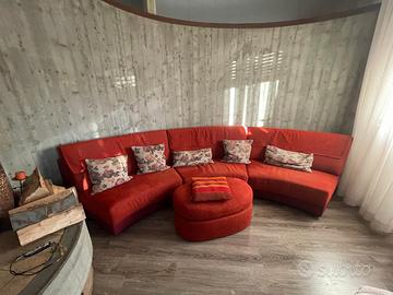 Divano angolare curvo rosso con pouf