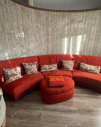 Divano angolare curvo rosso con pouf