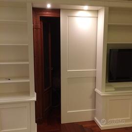 Parete con porta scorrevole e librerie