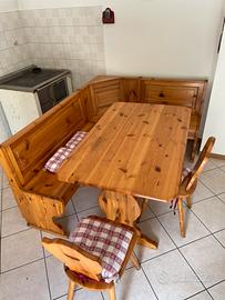 Tavolo in legno con panca ad angolo e sedie