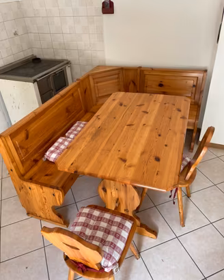 Tavolo in legno con panca ad angolo e sedie