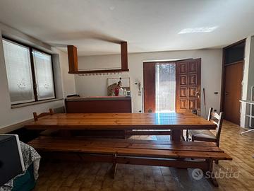 Tavolo in legno massiccio con due panche e sedie