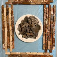 Ciottoli grigio scuro,  con tessee a due tagli.