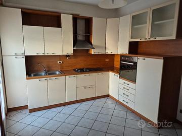 Cucina in buono stato d'uso con elettrodomestici.