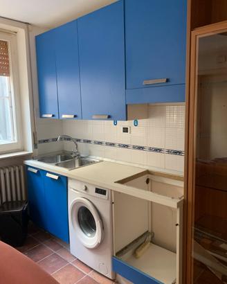 Cucina con lavatrice e frigorifero