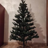 Albero di natale con puntale, luci e addobbi vari.