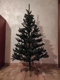 Albero di natale con puntale, luci e addobbi vari.