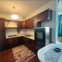 cucina in legno con penisola e elettrodomestici