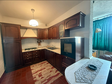 cucina in legno con penisola e elettrodomestici