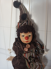 Pagliaccio sull'altalena con testa di porcellana