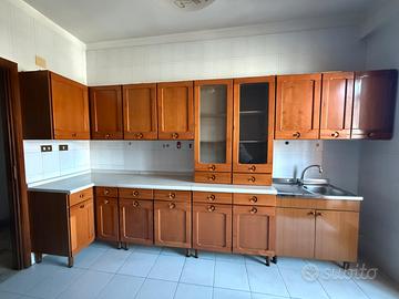 cucina completa di tavolo, sedie e cassettiera