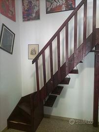 Scala con curva a sinistra di legno con ringhiera