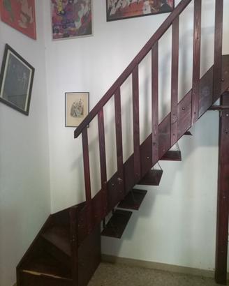 Scala con curva a sinistra di legno con ringhiera