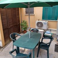 Tavolo da giardino con sedie e ombrellone