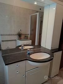 Mobile bagno con lavabo, specchio ed accessori.