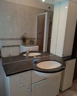 Mobile bagno con lavabo, specchio ed accessori.