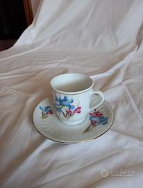Tazzine caffè con piattino e decorazioni floreali.