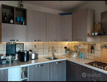 Cucina con lavastoviglie, forno , sedie e tavolo 