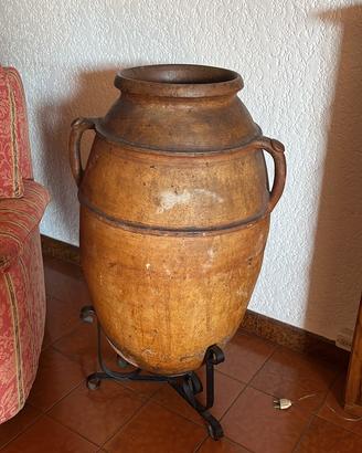Antica anfora in terracotta con supporto in ferro