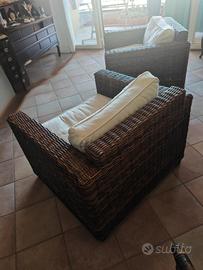 Poltrone in rattan e divano con cuscini bianchi