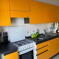 cucina arancione snaidero con forno e tavolo