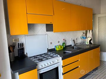 cucina arancione snaidero con forno e tavolo