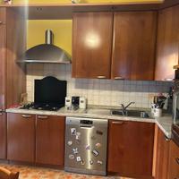 Cucina con elettrodomestici, tavolo e 6 sedie