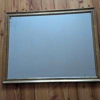 Specchio antico con cornice in legno dorata.