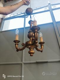 lampadario in legno dorato.