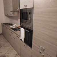 Cucina nuova con elettrodomestici e tavolo sedie 