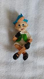 Pinocchio in resina con gambe incrociate