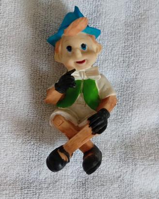 Pinocchio in resina con gambe incrociate