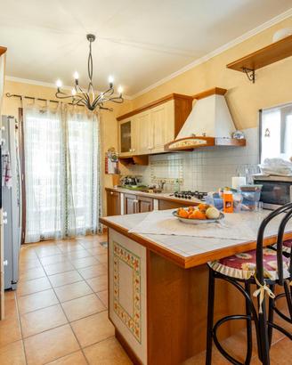 Cucina in finta muratura con penisola e sgabelli