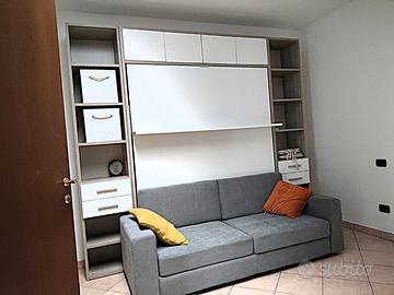 camera con letto a scomparsa e divano
