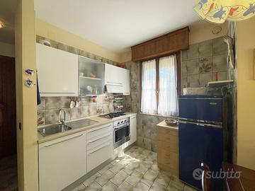 Cucina, tavolo, sedie e lavatrice