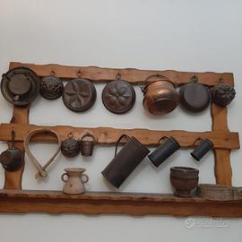 rastrelliera in legno con pentole di rame 