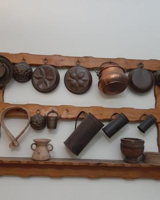 rastrelliera in legno con pentole di rame 