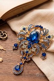 Spilla gioiello blu reale e oro con pendente