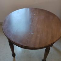 Tavolo rotondo in noce allungabile in ovale.