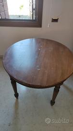 Tavolo rotondo in noce allungabile in ovale.