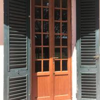 Porta a due ante a vetri in legno massello