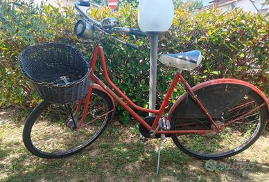Bici da donna rossa con cestino vintage 