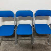Tre sedie richiudibili in plastica blu