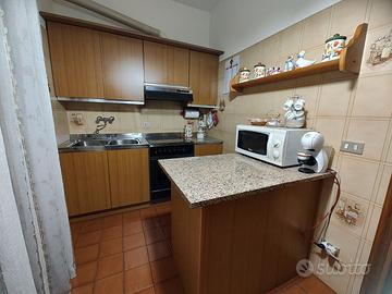 Cucina completa in legno chiaro con piano