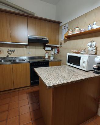 Cucina completa in legno chiaro con piano