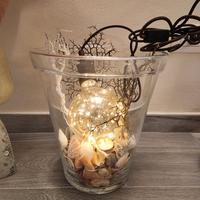 vaso in vetro con luci e conchiglie