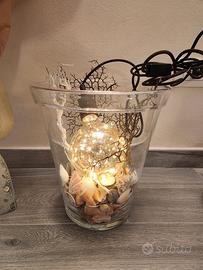 vaso in vetro con luci e conchiglie