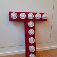 Lettera T rosso-bordeaux con luci