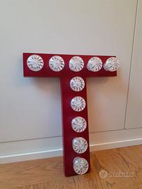 Lettera T rosso-bordeaux con luci