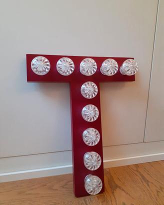 Lettera T rosso-bordeaux con luci